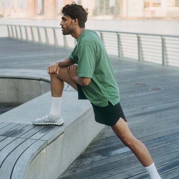 Person stretching outdoors during sunrise, symbolizing new energy.